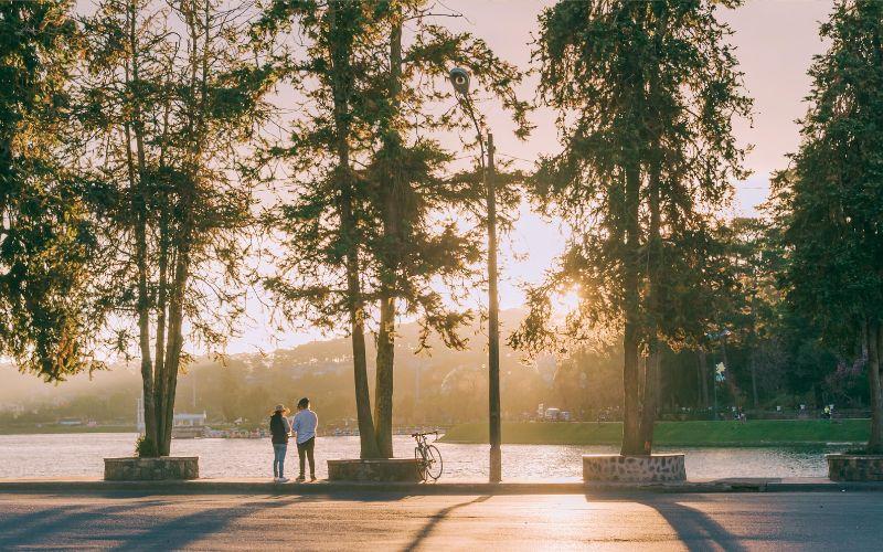 Two people near water under trees