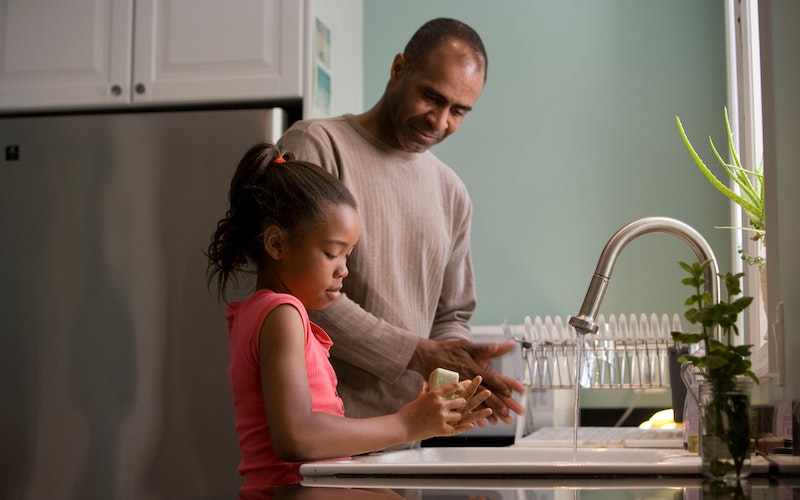 Dad and daughter practicing hand hygiene at home