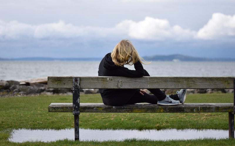 Person sitting on bench, reflecting