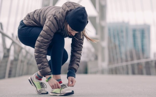 Person bending down to tie up shoelaces