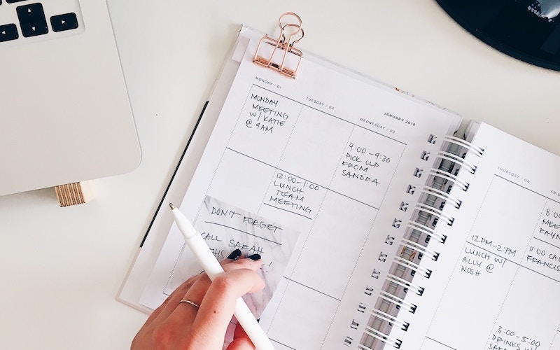 Person writing in personal calendar