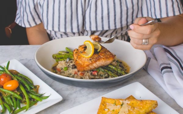 Person eating meal with oily fish